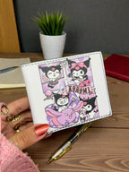 White wallet with cartoon character design held by a hand on a wooden surface.