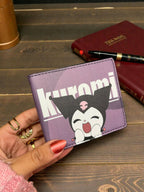 Purple wallet with cartoon character design held by a hand on a wooden surface.